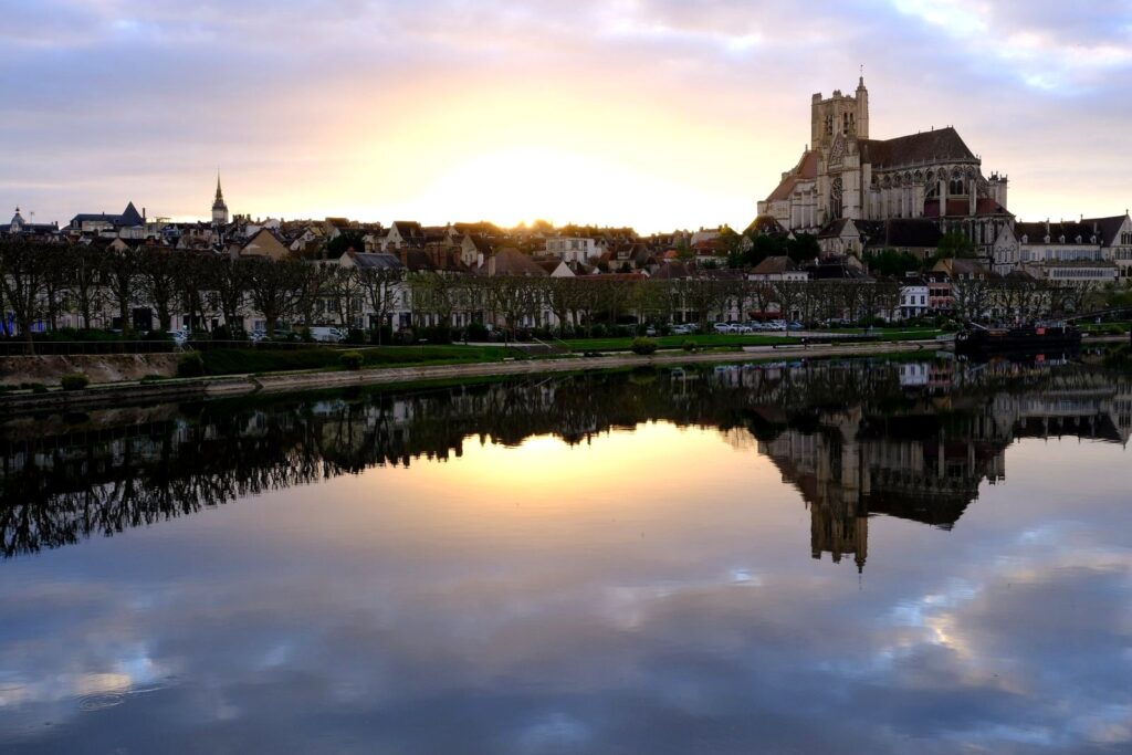 Auxerre cathedral at sunrise reflected in the Yonne river