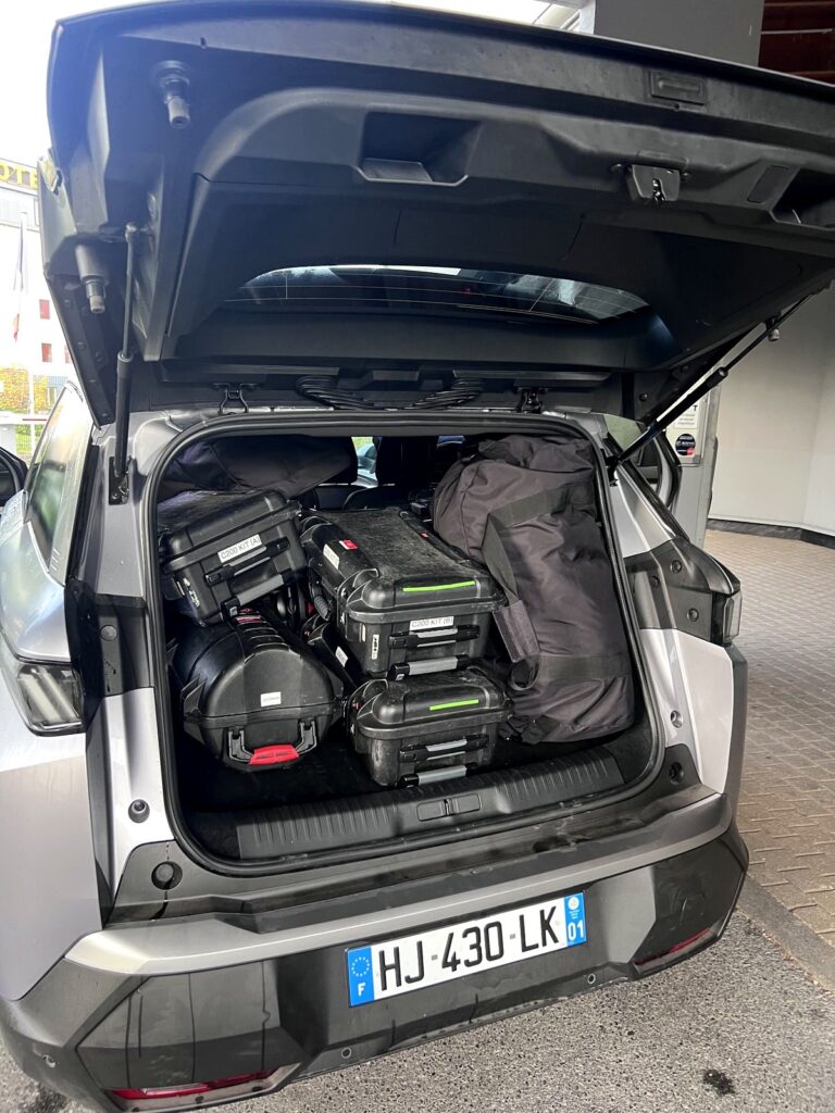 The rental SUV trunk packed tightly with camera gear