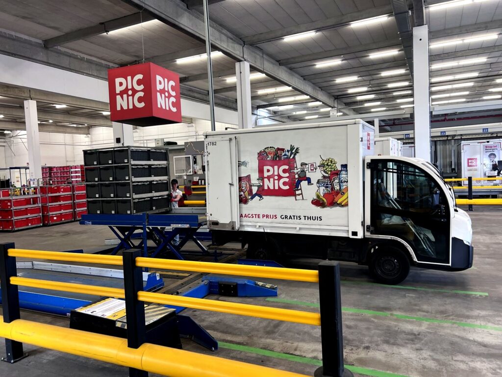 A Picnic electric delivery truck loaded with crates inside the depot