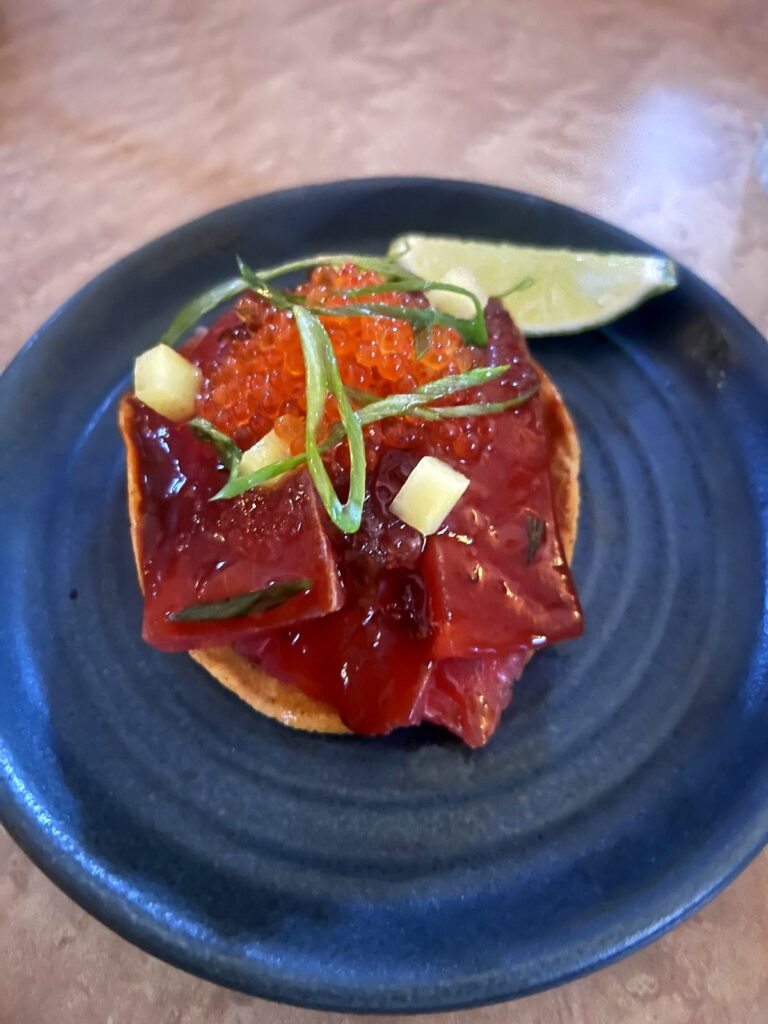 Tuna tostada on a blue plate at an Amsterdam restaurant