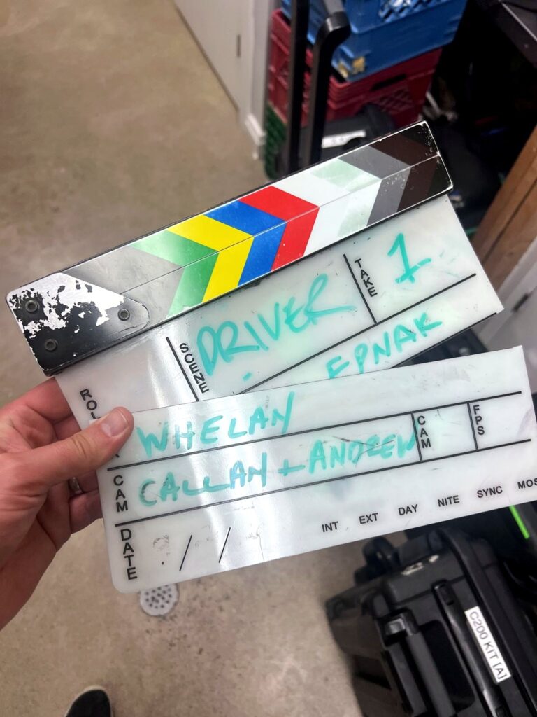 A film slate chalked with Driver, EPNAK and the crew names