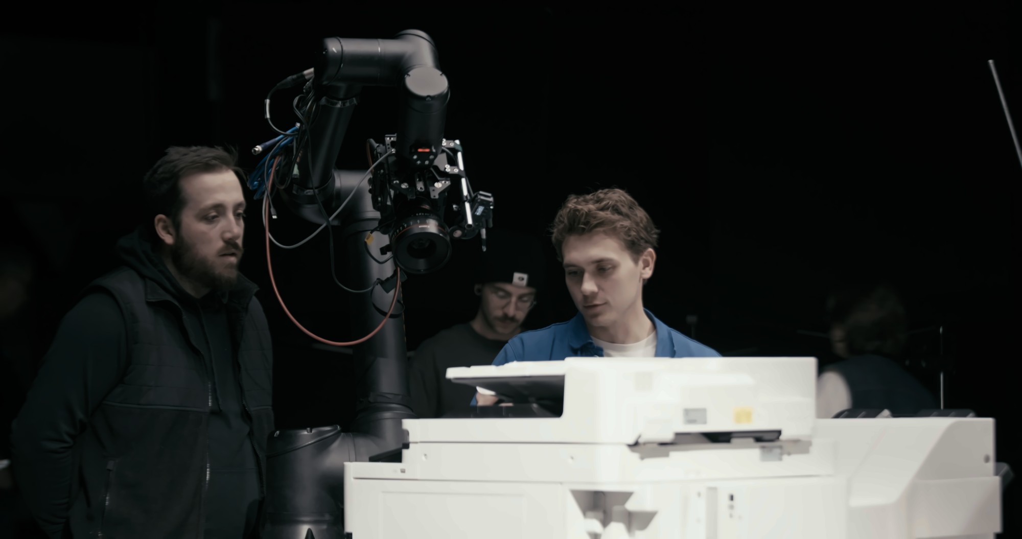 Three Arc Media crew members working around the printer between takes
