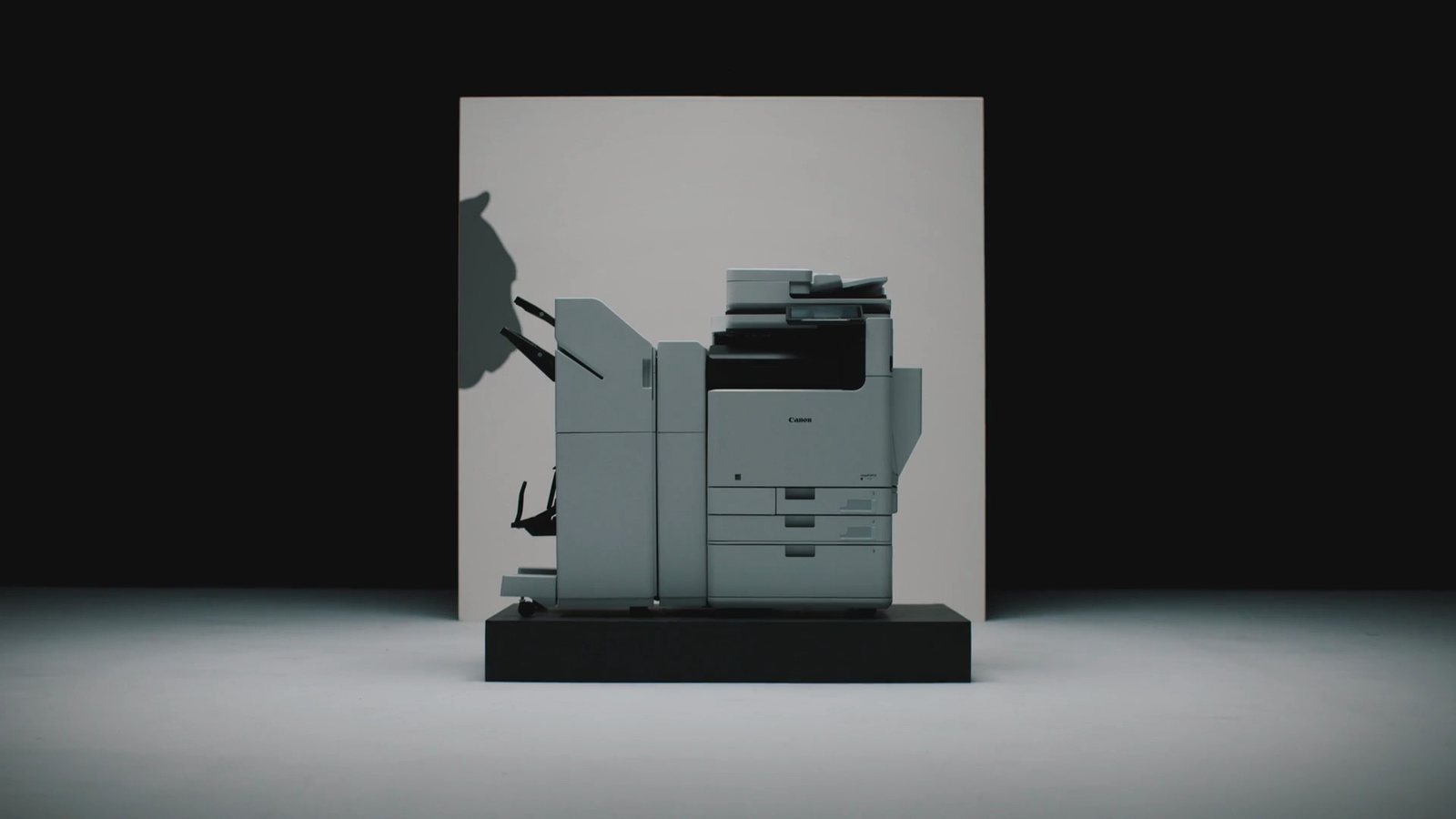 A Canon imageFORCE printer on a plinth in a neutral white studio environment