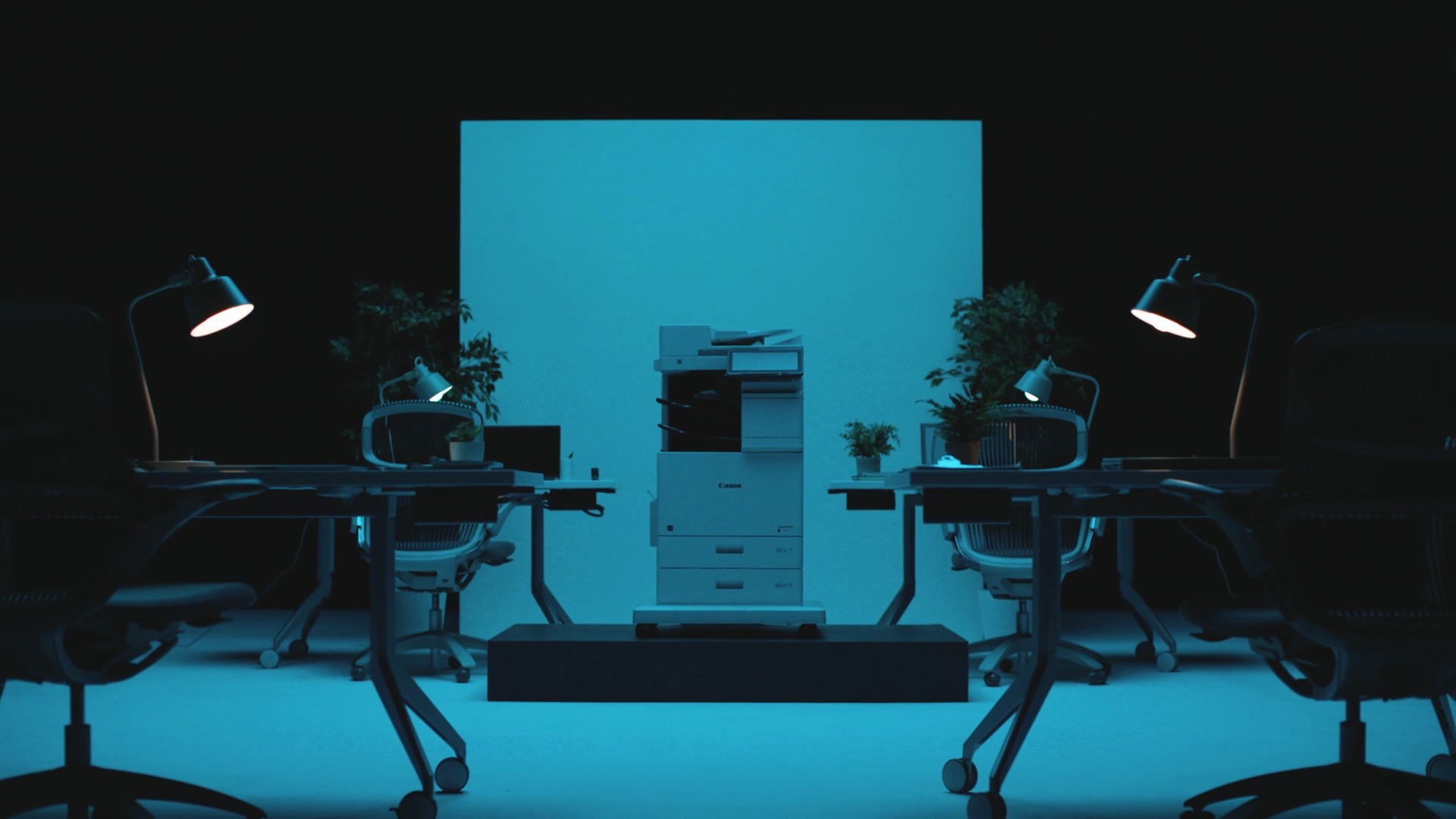 The printer in a blue-lit open-plan office environment